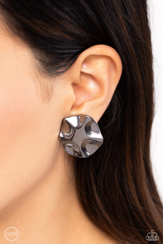 <p>Featuring a high sheen finish, wavy gunmetal discs are hammered and molded into a rustic industrial statement. Earring attaches to a standard clip-on fitting.</p> <p><i>Sold as one pair of clip-on earrings.</i></p> &nbsp;<img src="https://d9b54x484lq62.cloudfront.net/paparazzi/shopping/images/517_cliponicon_1.jpg" alt="Clip On Earring" align="middle" height="50" width="50">