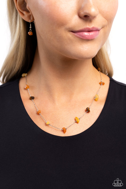 <p>Infused along a silver chain, orange, yellow, and tiger's eye stones, bordered by silver beads, sporadically dot around the collar for a simple, stony statement. Features an adjustable clasp closure. As the stone elements in this piece are natural, some color variation is normal.</p> <p><i> Sold as one individual necklace. Includes one pair of matching earrings.</i></p>