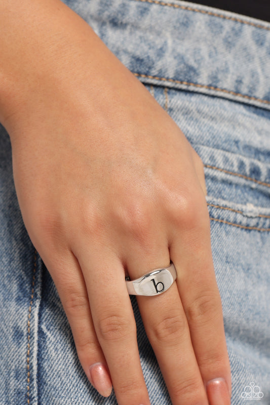 <p>Pressed into the center of a beveled silver band, the black letter "b" stands out for a simple, sentimental centerpiece. Features a stretchy band for a flexible fit.</p> <p><i> Sold as one individual ring.</i></p>