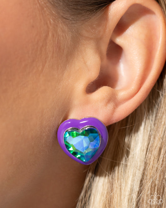 <p>Pressed in a border of purple paint, an oversized UV shimmery heart gem glimmers from the ear, resulting in a romantic-inspired display. Earring attaches to a standard post fitting.</p> <p><i> Sold as one pair of post earrings. </i></p> <br><b> Get The Complete Look! </b> <br>Necklace: "Heartfelt Hope - Purple" (Sold Separately)