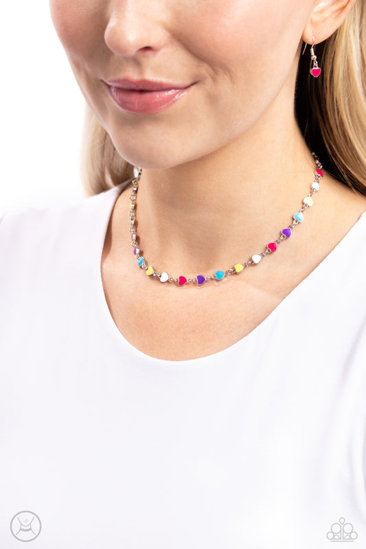 <p>Multicolored-painted silver hearts interconnect around the collar for a simply sentimental look. Features an adjustable clasp closure.</p> <p><i>Sold as one individual choker necklace. Includes one pair of matching earrings. </i></p> &nbsp;<img src="https://d9b54x484lq62.cloudfront.net/paparazzi/shopping/images/517_chokericon_1.jpg" alt="Choker" align="middle" height="50" width="50">