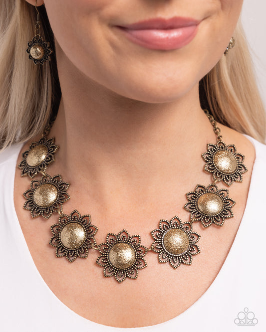 <p>Studded in tactile detail, a collection of brass mandala-like floral frames with brass glittery centers connect below the collar from a classic brass chain for a gorgeous pop of color. Features an adjustable clasp closure.</p> <p><i> Sold as one individual necklace. Includes one pair of matching earrings.</i></p>