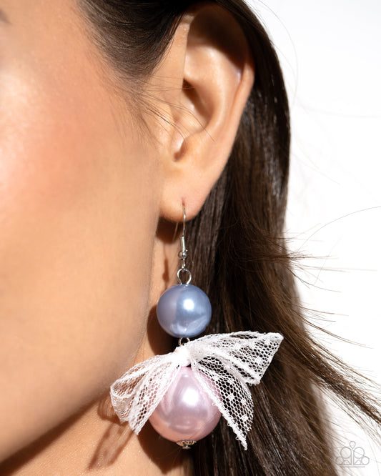 <p>Two glossy pearls one in blue and one in pink stack atop one another while an airy, chiffon white ribbon is tied in the center of the pearls for a refined finish. Earring attaches to a standard fishhook fitting.</p> <p><i> Sold as one pair of earrings. </i></p> <br><b> Get The Complete Look! </b> <br>Bracelet: "Girly Glam - Multi" (Sold Separately)
