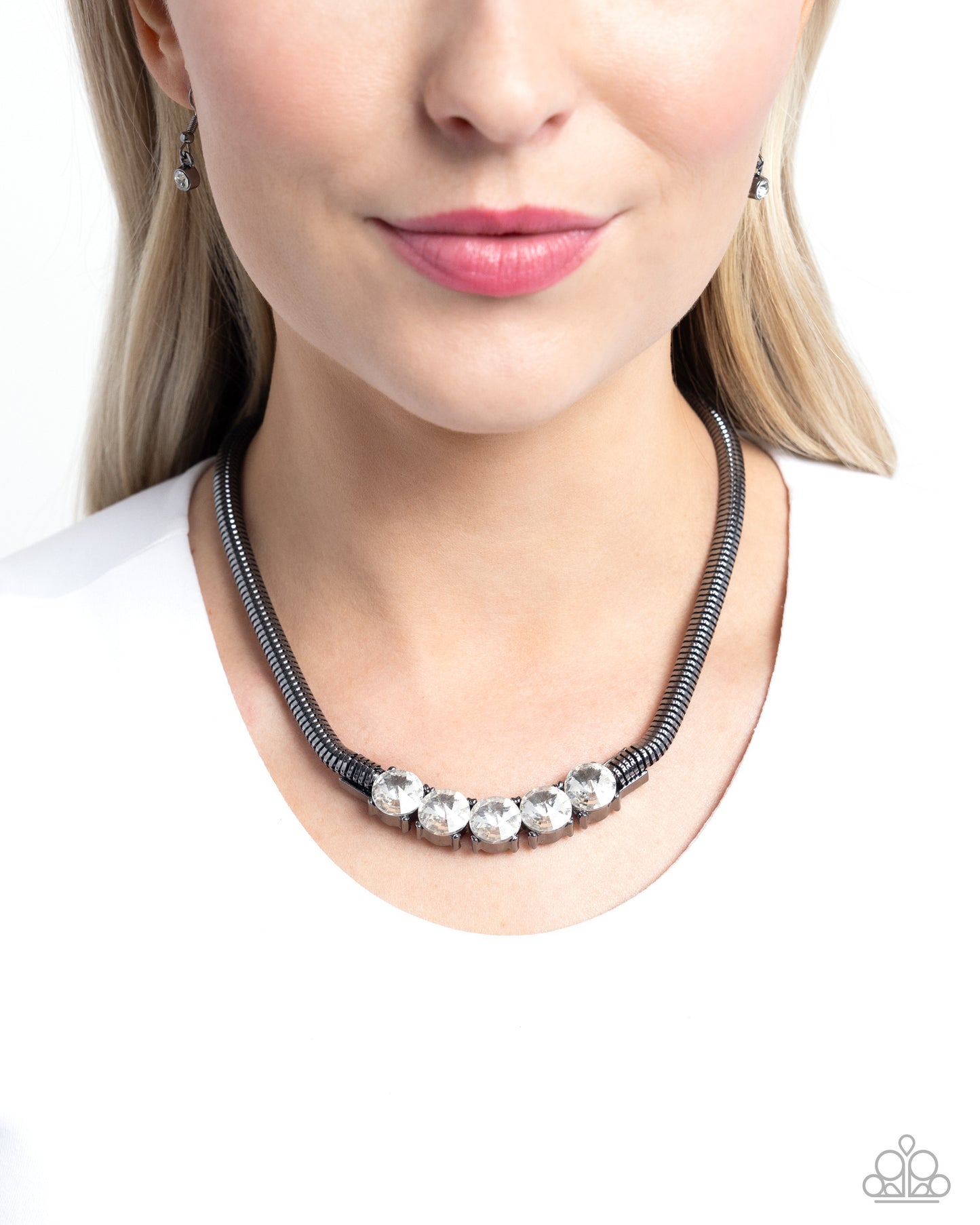 <p>Pronged in place along the center of a thick gunmetal chain, faceted white gems twinkle below the neckline for a glittery, grungy look. Features an adjustable clasp closure.</p> <p><i> Sold as one individual necklace. Includes one pair of matching earrings.</i></p>