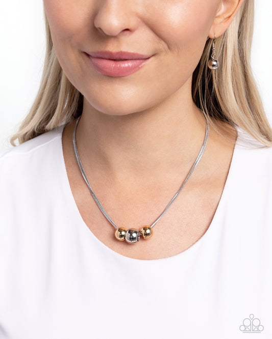 <p>Strung along a trio of silver snake chains, two gold beads frame an oversized silver bead for a simple, high-sheen statement. Features an adjustable clasp closure.</p> <p><i> Sold as one individual necklace. Includes one pair of matching earrings.</i></p>