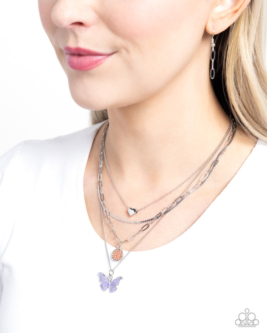 <p>A quartet of mismatched silver chains loop and layer below the neckline. A silver heart, Desert Flower gem-encrusted silver pendant, and lavender painted silver butterfly glide along the chains for a whimsical finish. Features an adjustable clasp closure.</p> <p><i> Sold as one individual necklace. Includes one pair of matching earrings.</i></p>