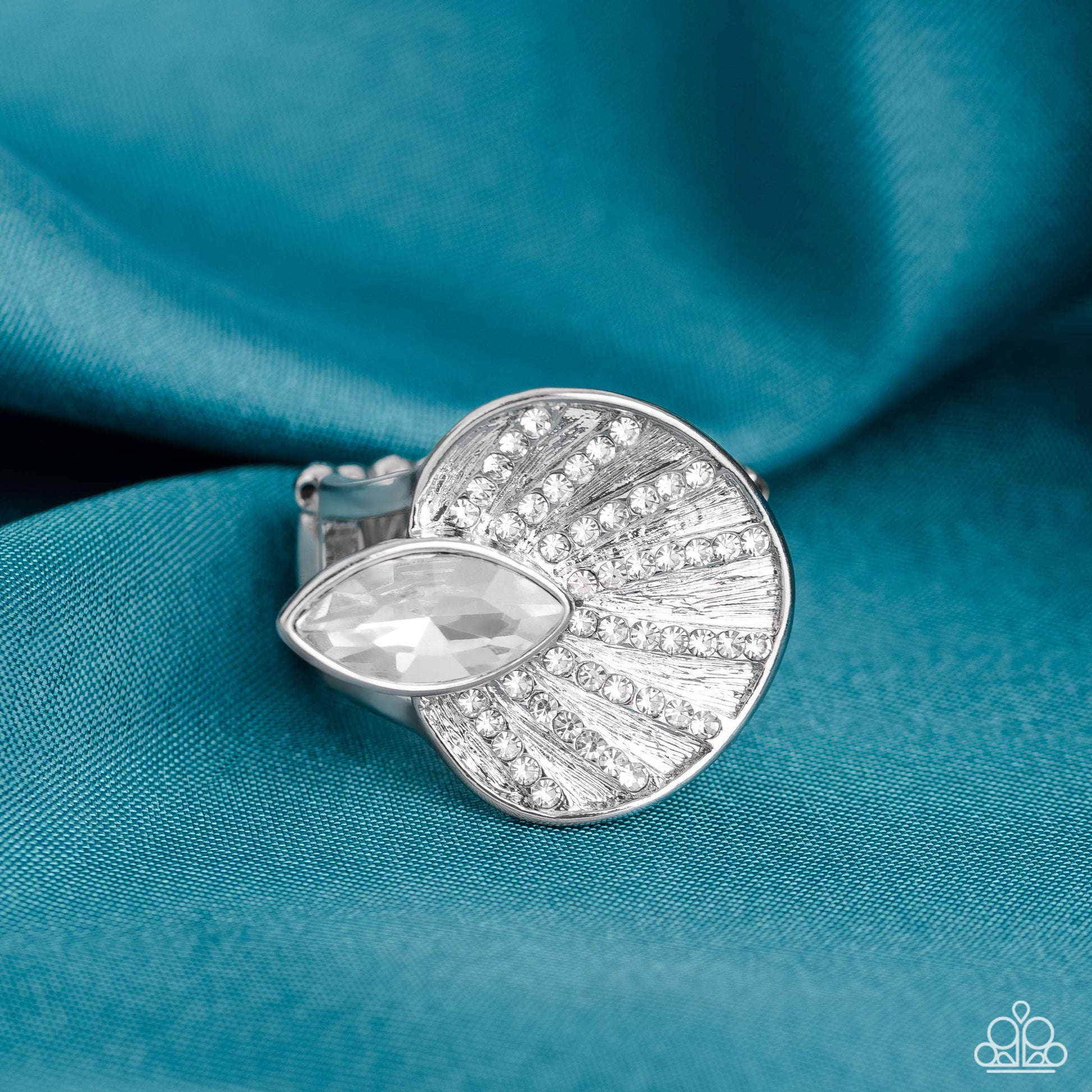 An asymmetrical silver disc, featuring linear layers of dainty white rhinestones against a textured backdrop, reflect light off its every angle from airy silver bands. A marquise-cut white gem interrupts the fan-like pendant, creating additional shine to the glitzy display. Features a stretchy band for a flexible fit.  Sold as one individual ring.