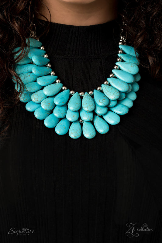 Three trailblazing tiers of shiny silver beads and turquoise teardrops fearlessly cascade into a bold tribal inspired fringe below the collar. Attached to a chunky silver chain, the groundbreaking stone compilation delicately layers into an earth-rattling statement-maker. Features an adjustable clasp closure.  Named after 2020 Rock the Runway winner, Amy K.  Sold as one individual necklace. Includes one pair of matching earrings.