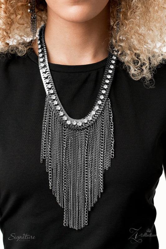 A sassy curtain of mismatched gunmetal chains tapers from the bottom of a dramatic row of glassy white rhinestones that have been delicately fastened to an edgy row of flattened gunmetal chain. The exaggerated fringe cascades down the chest, resulting in a dauntless attitude that demands attention with every swish of the fearless fringe. Features an adjustable clasp closure.  Named after 2020 Rock the Runway winner, Alex M.  Sold as one individual necklace. Includes one pair of matching earrings.