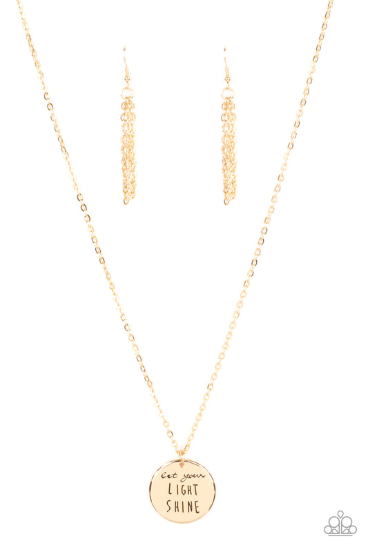 A glistening gold disc is stamped in the inspiring phrase, "Let your light shine," at the bottom of a shiny gold chain. Features an adjustable clasp closure.  Sold as one individual necklace. Includes one pair of matching earrings.