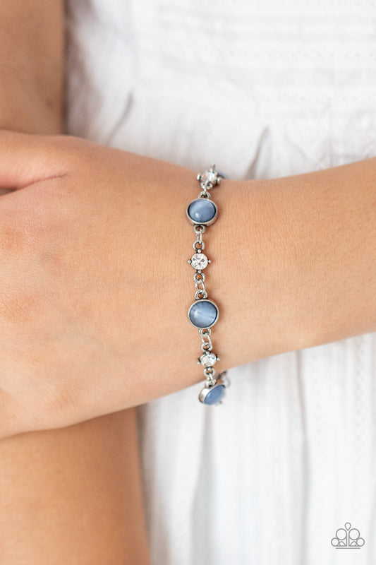Encased in antiqued silver fittings, dainty white rhinestones and glowing Cerulean cat's eye stones delicately link around the wrist for a timeless finish. Features an adjustable clasp closure.  Sold as one individual bracelet.   Get The Complete Look!  Necklace: "Inner Illumination - Blue" (Sold Separately)