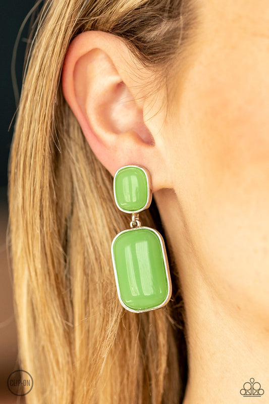 Encased in sleek silver frames, milky Green Ash beads link into an oversized lure for a whimsically refined flair. Earring attaches to a standard clip-on fitting.  Sold as one pair of clip-on earrings.   Clip On Earring