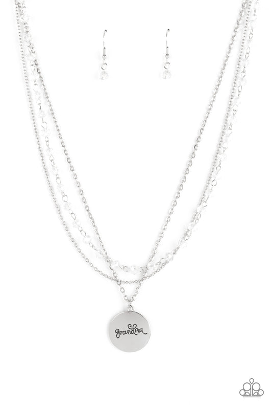 Infused with a strand of iridescent crystal-like beads, two dainty rows of mismatched silver chains delicately layer below the collar. Stamped in the word, "Grandma," a shiny silver disc swings from the lowest chain, creating a loving pendant. Features an adjustable clasp closure.  Sold as one individual necklace. Includes one pair of matching earrings.