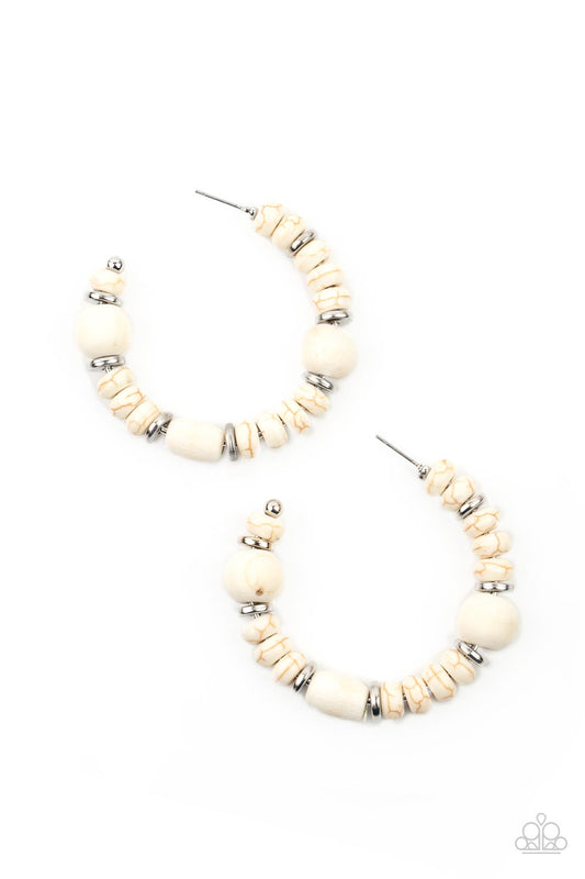 An earthy collection of white stone beads, silver discs, and white wooden beads are delicately threaded along a dainty wire, creating an artisan inspired hoop. Earring attaches to a standard post fitting. Hoop measures approximately 2" in diameter.  Sold as one pair of hoop earrings.