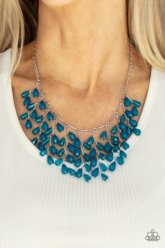 A shimmery collection of opaque and clear crystal-like Mykonos Blue teardrop beads delicately cluster along a linked strand of silver bars, creating an ethereally leafy fringe below the collar. Features an adjustable clasp closure.  Sold as one individual necklace. Includes one pair of matching earrings.