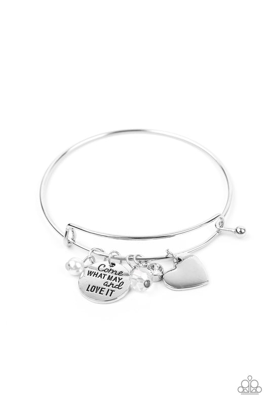 Infused with a shiny silver heart frame, a dainty silver disc stamped in the phrase, "Come what may and love it," joins pearl, crystal, and rhinestone charms along a bangle-like bracelet for a whimsy look. Features a toggle closure.  Sold as one individual bracelet.