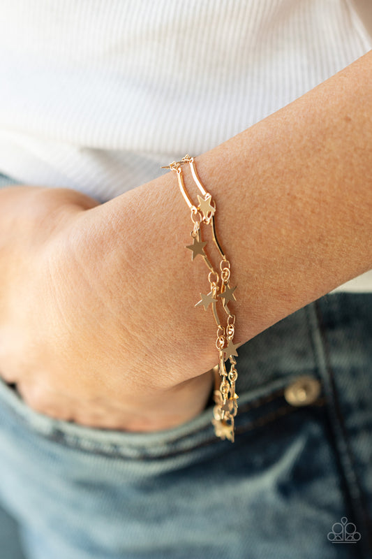 A collection of dainty gold stars and curved gold bars delicately connect around the wrist, creating a stellar fringe. Features an adjustable clasp closure.  Sold as one individual bracelet.