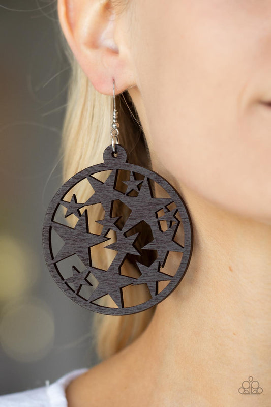 An oversized round brown wooden frame is filled with a cosmos of cut-out brown stars creating a whimsical statement. Earring attaches to a standard fishhook fitting.  Sold as one pair of earrings.