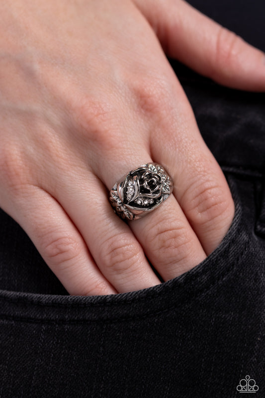 Dotted in dainty white rhinestones, a leafy silver rosebud blooms across a plain silver band for an enchanting floral fashion. Features a dainty stretchy band for a flexible fit.  Sold as one individual ring.