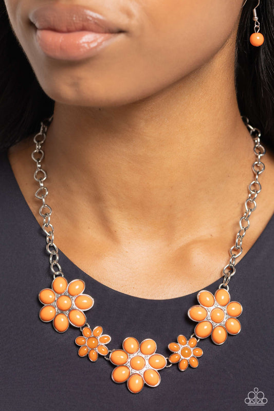 A flirtatious collection of orange dotted floral frames alternate with dainty opaque orange flowers below the collar, creating a vivacious pop of color. Features an adjustable clasp closure.  Sold as one individual necklace. Includes one pair of matching earrings.