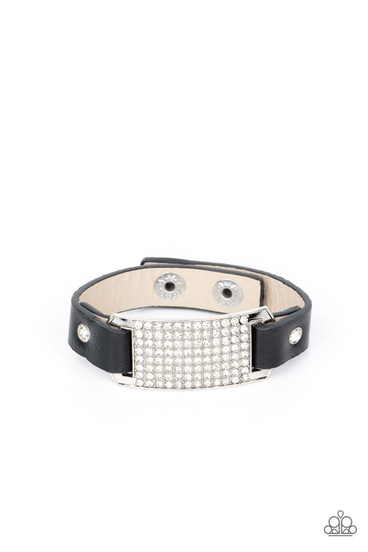 Black leather bands are looped through the ends of a white rhinestone embellished silver frame and studded in place with glitzy white rhinestone studs, creating a glamorous centerpiece around the wrist. Features an adjustable snap closure.  Sold as one individual bracelet.