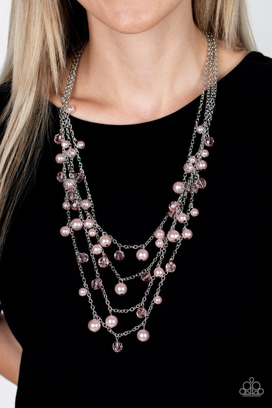 Row after row of bubbly pink pearls and glittery crystal-like beads swing from layered silver chains across the chest, creating a noise-making display. Features an adjustable clasp closure.  Sold as one individual necklace. Includes one pair of matching earrings.