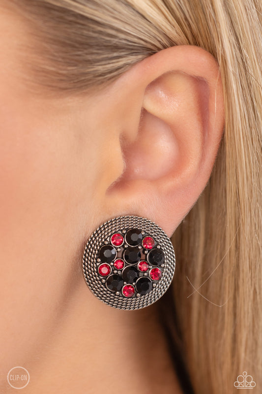 A glitzy collection of red and black rhinestones are encircled with a silver rope-like border, resulting in a smoldering centerpiece. Earring attaches to a standard clip-on fitting.  Sold as one pair of clip-on earrings.   Clip On Earring