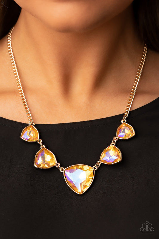 Encased in sleek gold fittings, an oversized collection of UV geometric gems gradually increase in size as they link below the collar for a golden statement. Features an adjustable clasp closure.  Sold as one individual necklace. Includes one pair of matching earrings.