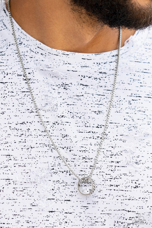 Embossed in a band of zigzagging texture, an antiqued silver ring glides along a strand of silver box chain across the chest in a rustic fashion. Features an adjustable clasp closure.  Sold as one individual necklace.