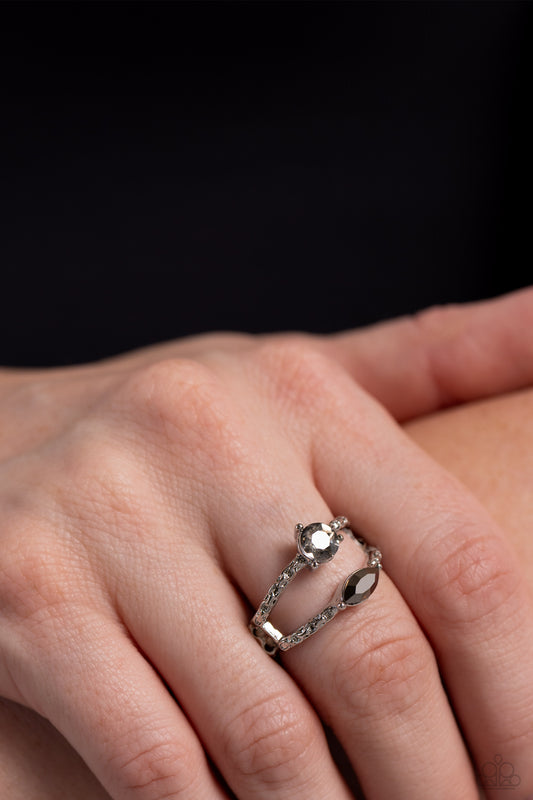 A mismatched pair of round smoky and marquise cut hematite rhinestones sits atop a pair of hammered silver bands, layering into a smoldering centerpiece atop the finger. Features a dainty stretchy band for a flexible fit.  Sold as one individual ring.