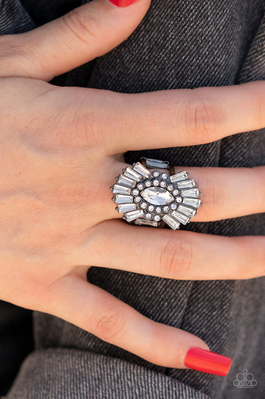 A white, marquise-cut rhinestone is bordered in glassy white rhinestones atop fans of trapezoidal-cut white rhinestones, resulting in an edgy sparkle that explodes atop the finger. Features a stretchy band for a flexible fit.  Sold as one individual ring.