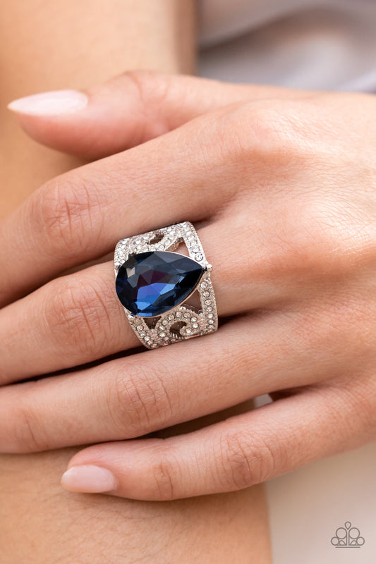 An oversized teardrop gem in the Pantone® of Polar Night embellishes the center of a regal, filigree-filled band dotted in glassy white rhinestones, invoking a royal radiance atop the finger. Features a stretchy band for a flexible fit.  Sold as one individual ring.