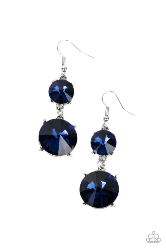 Featuring pronged silver fittings, two oversized blue rhinestones dramatically link into a bold smoldering lure as they drip dazzlingly from the ear. Earring attaches to a standard fishhook fitting.  Sold as one pair of earrings.