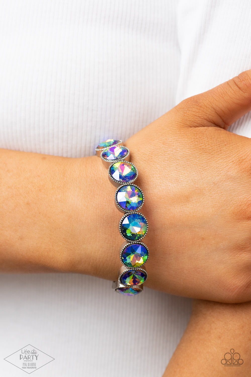 Faceted oil spill-like iridescent gems are pressed into sleek silver frames. The glittery frames are threaded along elastic stretchy bands, creating a glamorous look around the wrist.  Sold as one individual bracelet.