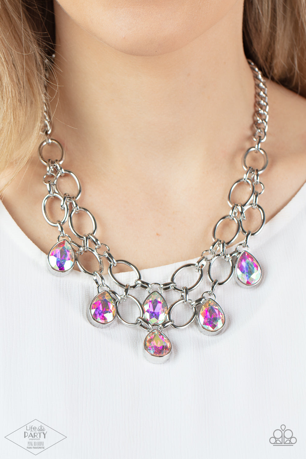 Joined by dainty silver links, two rows of dramatic silver chain layer below the collar in a fierce fashion. Iridescent teardrop gems drip from the glistening layers, adding a timeless shimmer to the show-stopping piece. Features an adjustable clasp closure.  Sold as one individual necklace. Includes one pair of matching earrings.   FANFAVORITE