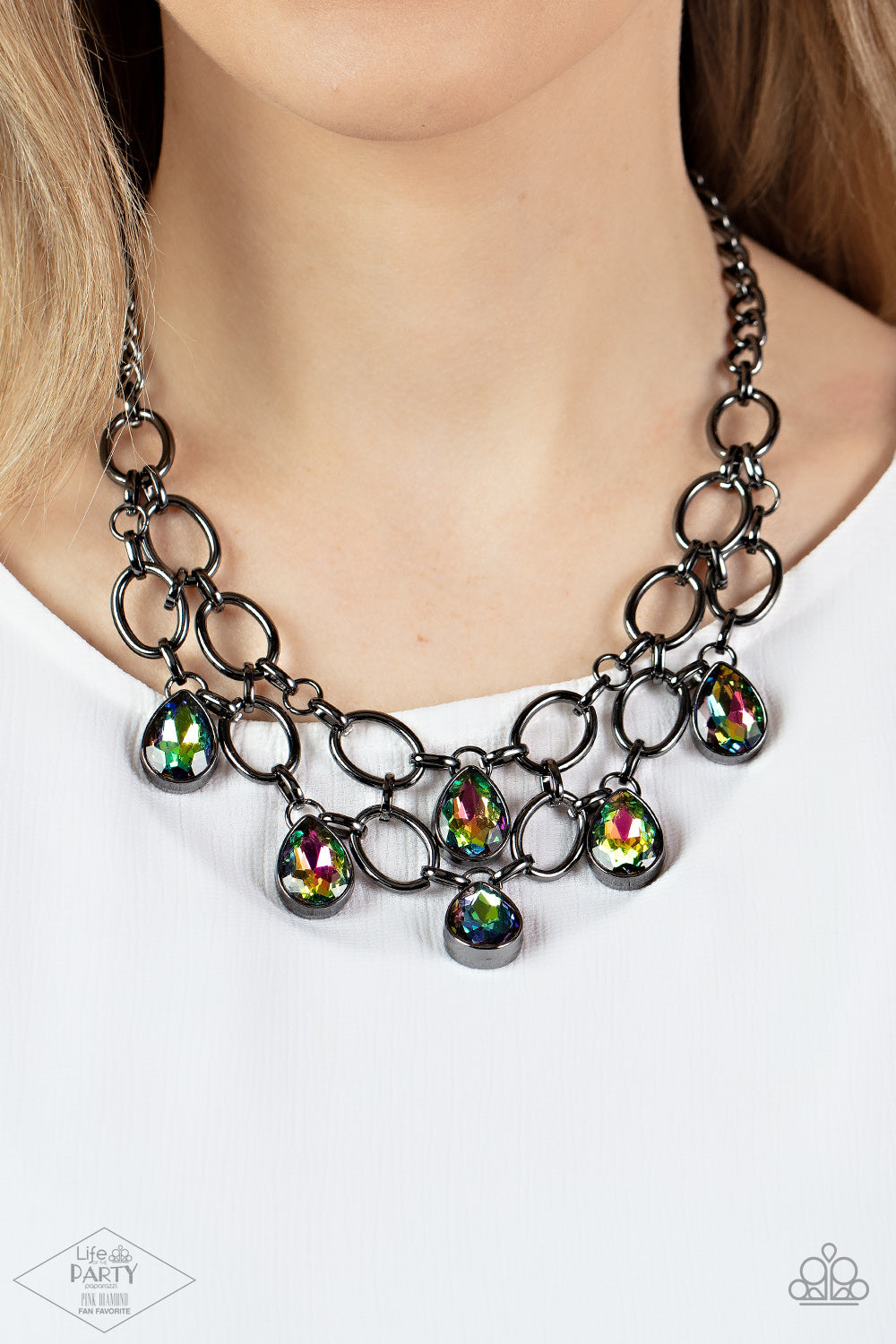 Joined by dainty gunmetal links, two rows of dramatic gunmetal chain layer below the collar in a fierce fashion. Oil spill teardrop gems drip from the glistening layers, adding a timeless shimmer to the show-stopping piece. Features an adjustable clasp closure.  Sold as one individual necklace. Includes one pair of matching earrings.   FANFAVORITE
