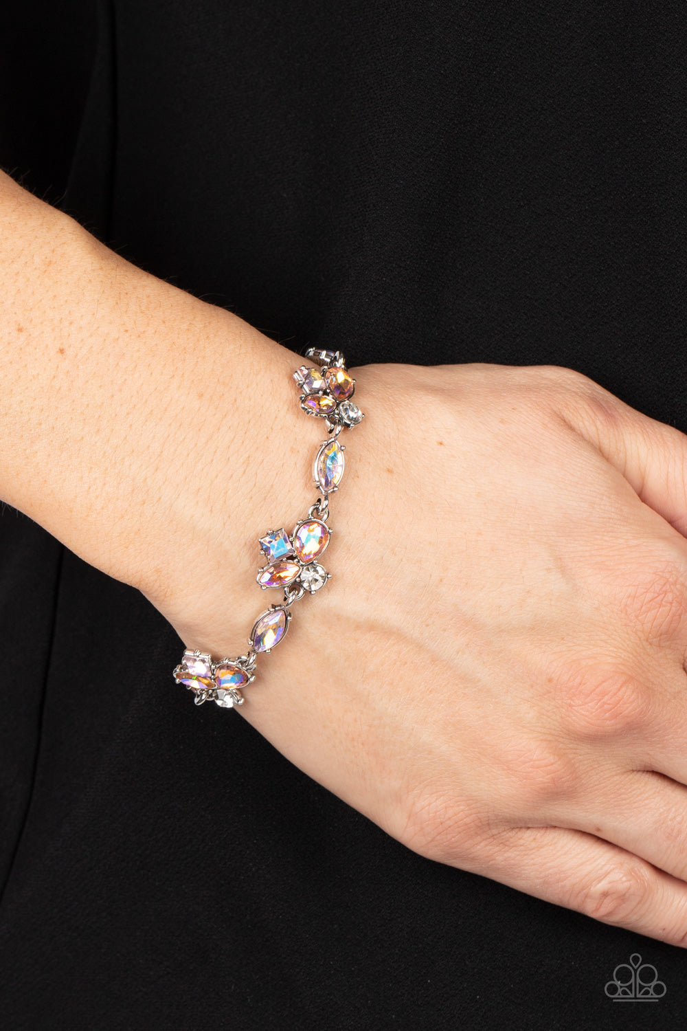Featuring various cuts and finishes, dainty clusters of white, pink, and orange iridescent rhinestones delicately link with marquise cut rhinestones around the wrist for an effervescent elegance. Features an adjustable clasp closure.  Sold as one individual bracelet.