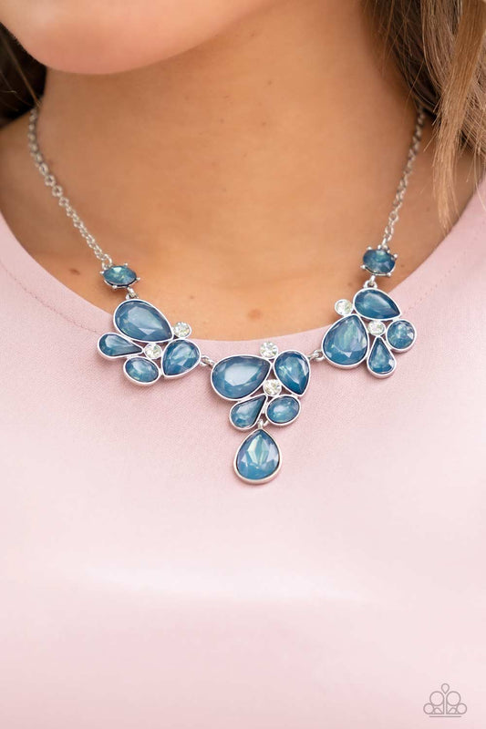 Draped elegantly across the chest, clusters of geometric blue gems, brushed in the fall Pantone® of Midnight, gather around sparkling white rhinestones, creating a bright and beautiful pattern. Features an adjustable clasp closure.  Sold as one individual necklace. Includes one pair of matching earrings.