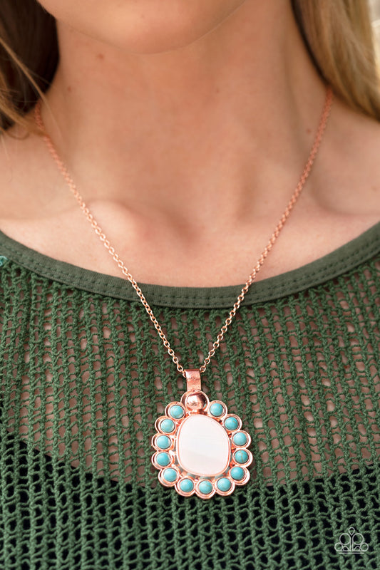 Dangling from a shiny copper chain, an asymmetrical white shell with an opal finish is encircled by a turquoise stone-studded frame, creating a seasonal Southwestern pattern. As the stone elements in this piece are natural, some color variation is normal. Features an adjustable clasp closure.  Sold as one individual necklace. Includes one pair of matching earrings.