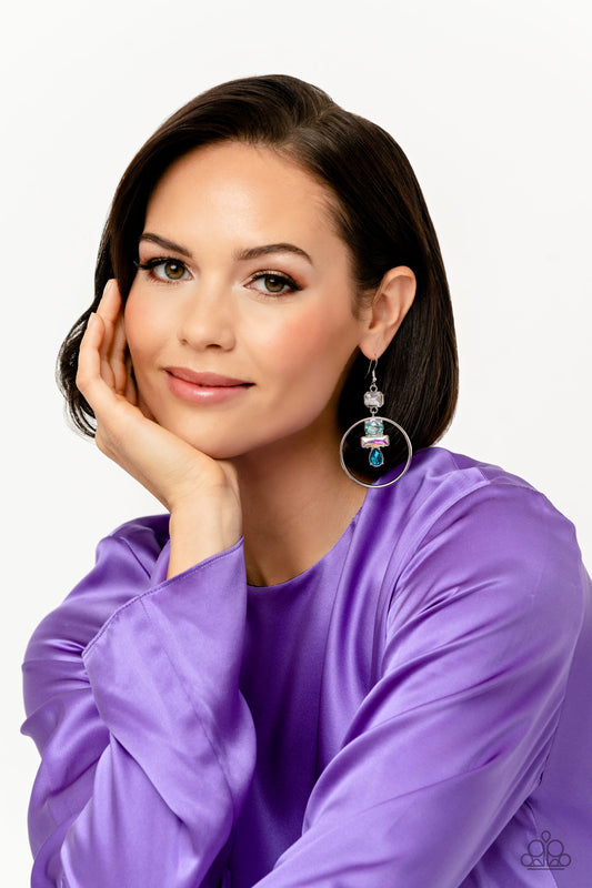 Dangling from an asscher-cut white gem, a trio of blue and iridescent geometric-shaped gems glimmer inside airy silver hoops. Earring attaches to a standard fishhook fitting. Due to its prismatic palette, color may vary.  Sold as one pair of earrings.