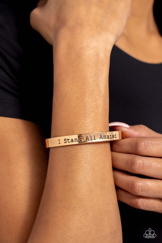 A simplistic, shiny, gold cuff is stamped with the phrase "I Stand All Amazed," for a divine, light-catching design across the wrist.  Sold as one individual bracelet.