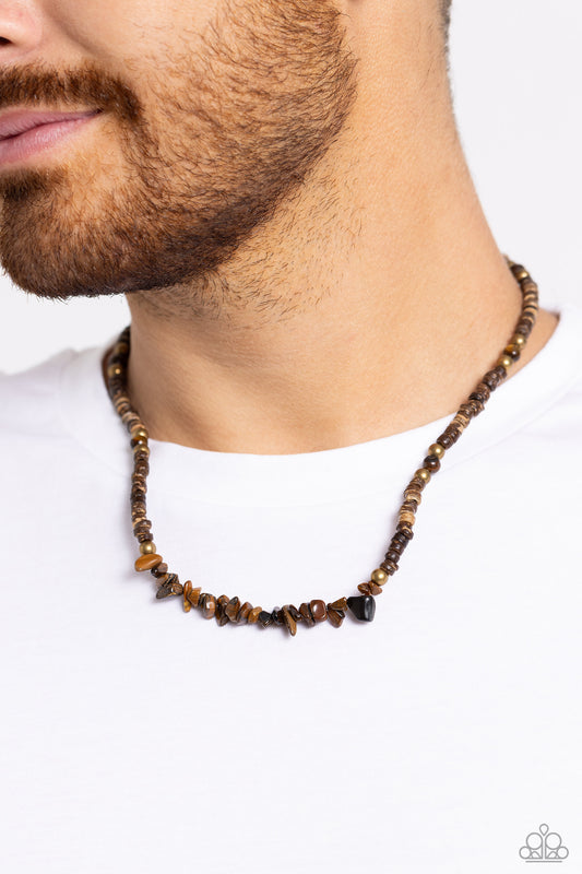 Threaded along an invisible wire, brown wooden beads, brass beads, and tiger's eye pebbles and beads haphazardly coalesce down the neckline for an earthy finish. Features an adjustable clasp closure. As the stone elements in this piece are natural, some color variation is normal.  Sold as one individual necklace.