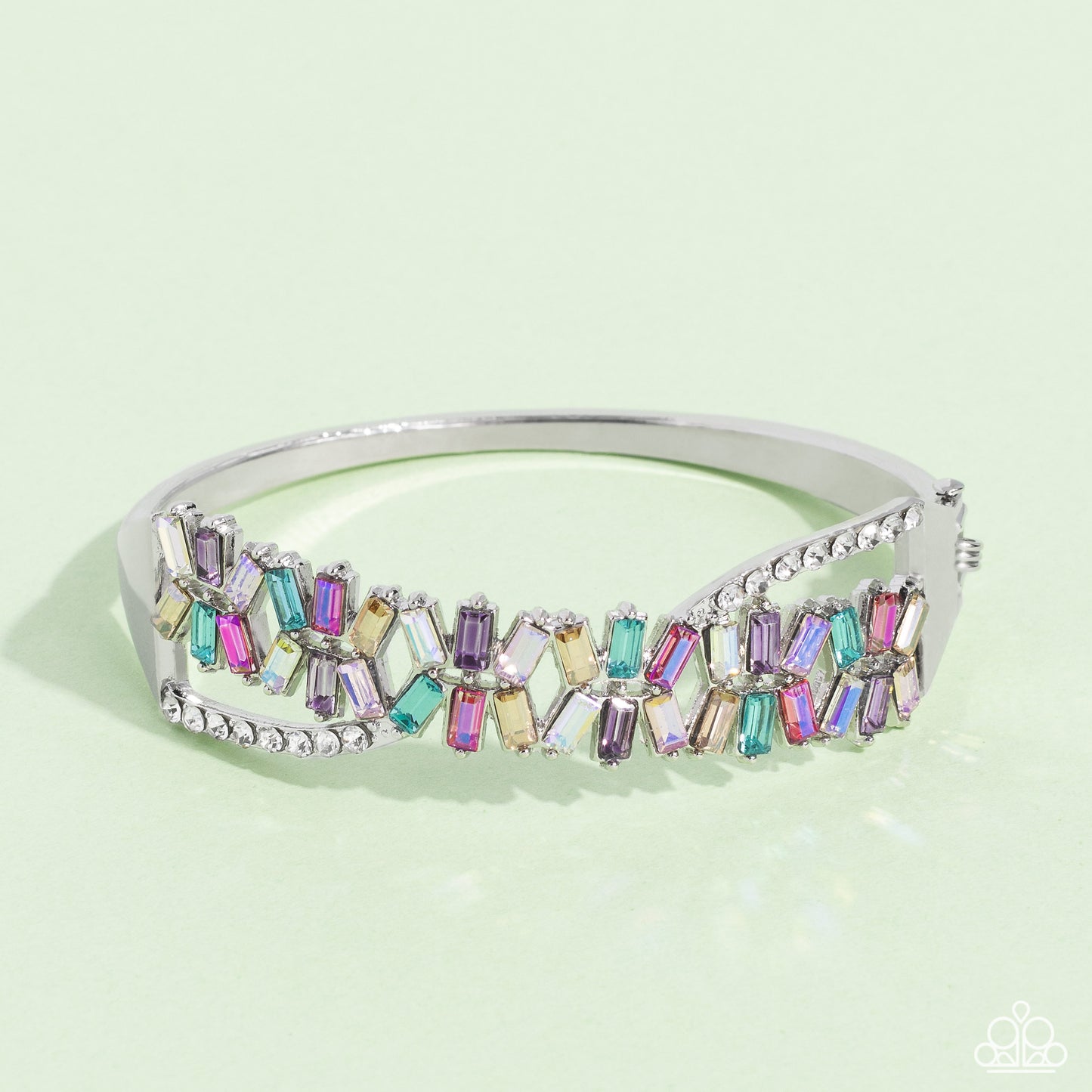 Modeled after the infinity symbol curves, a row of dainty white rhinestones playfully interacts with emerald-cut gems splashed in shades of amethyst, light blue, pink, smoked topaz, and iridescence. Set in clusters of three, the emerald-cuts haphazardly stack on top of one another for a timeless, geometric radiance atop the wrist. Due to its prismatic palette, color may vary. Features a hinged closure.  Sold as one individual bracelet.