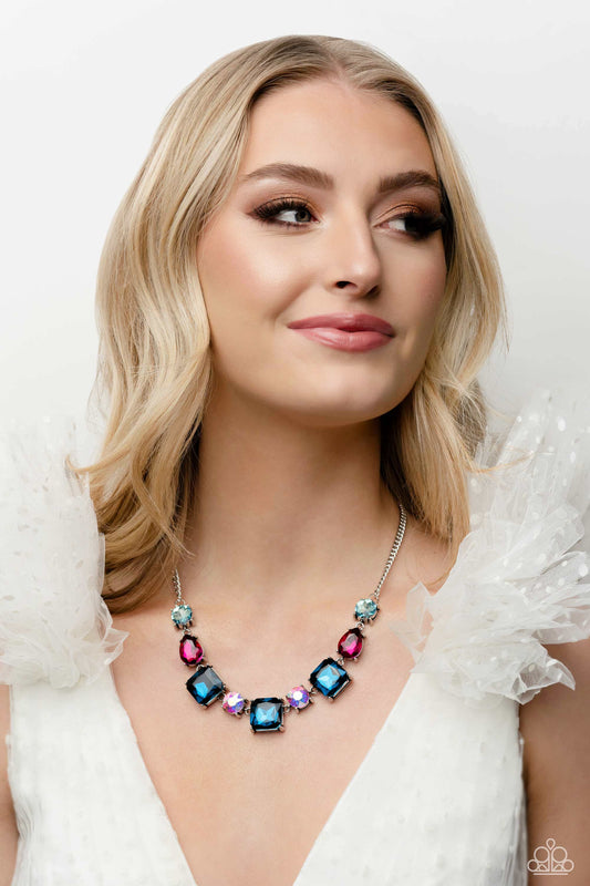 Encased within thick, pronged, elevated silver settings, a geometric collection of fuchsia, light blue, dark blue, and iridescent rhinestones, featured in square, teardrop, and round shapes coalesces down the neckline for a gritty, yet glamorous display. Features an adjustable clasp closure. Due to its prismatic palette, color may vary.  Sold as one individual necklace. Includes one pair of matching earrings.