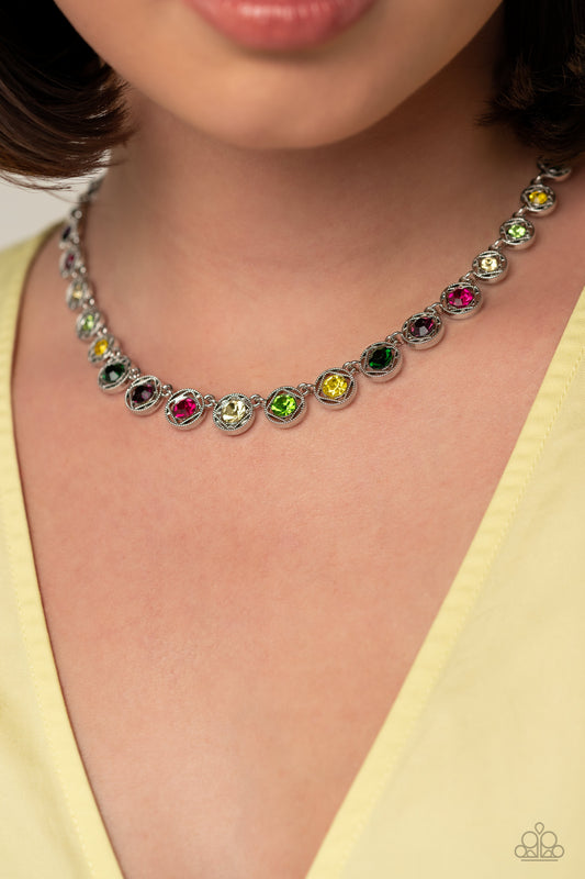 Spanning around the entirety of the neckline, a refined collection of colorful rhinestones are pressed into airy, studded, silver square frames, tilted on their sides for a three-dimensional shimmer. The frames and rhinestones gradually increase in size as they fall down the neckline, accentuating their colorful sparkle. Features an adjustable clasp closure.     Sold as one individual necklace. Includes one pair of matching earrings.