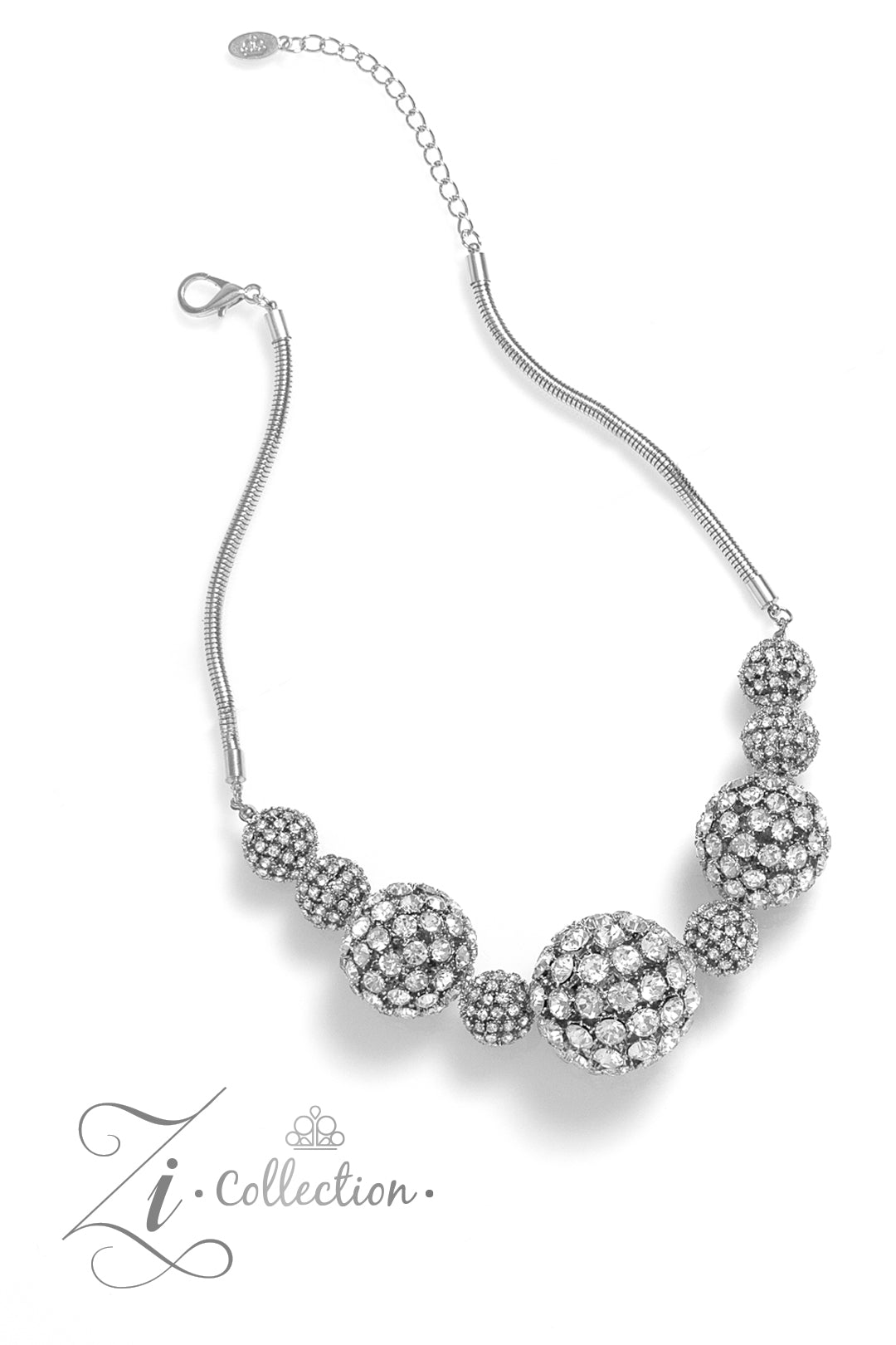 Glittery, white rhinestones cluster together, creating dramatically oversized, airy, spheres that sparkle vivaciously. Smaller rhinestone-encrusted spheres dance between the exaggerated accents, resulting in a dynamic display of texture and sheen. Features an adjustable clasp closure.  Sold as one individual necklace. Includes one pair of matching earrings.