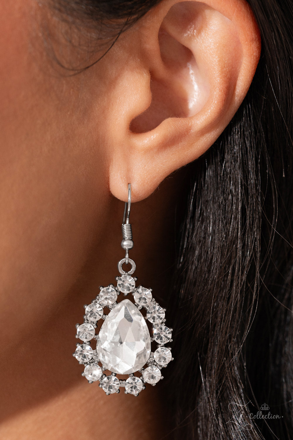 Brilliant white rhinestones, in both round and oval cuts, link around the neck in a stunning display. Each dramatically faceted gem is encircled by tiny white rhinestones set in pronged fittings, bringing a vintage charisma to the design. The floral-inspired frames gradually increase in size as they lead towards the center, where a teardrop-shaped gem drips into the spotlight. Features an adjustable clasp closure.  Sold as one individual necklace. Includes one pair of matching earrings.