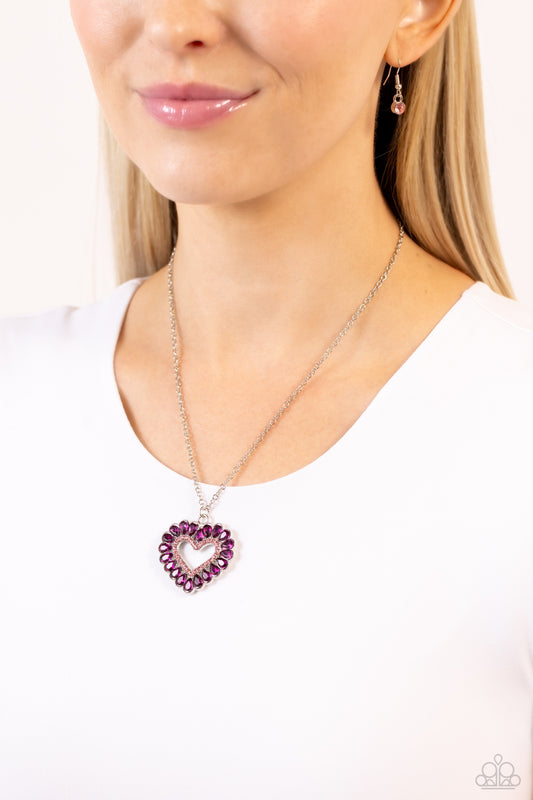 Featuring silver studded frames, fuchsia teardrop gems form into a glitzy heart pendant at the bottom of a dainty silver chain. Light pink rhinestones border the inner heart frame, leaving an airy heart silhouette to glide down the chest for a flirtatiously colorful finish. Features an adjustable clasp closure.  Sold as one individual necklace. Includes one pair of matching earrings.