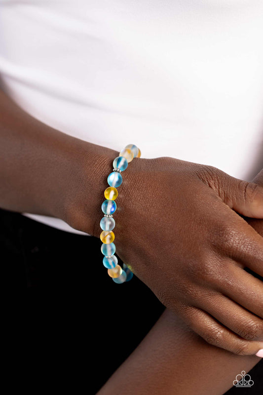 Infused with silver floral beads, a glassy collection of reflective blue and yellow-colored stone beads are threaded along an elastic stretchy band around the wrist for an adventurous pop of urban color.  Sold as one individual bracelet.