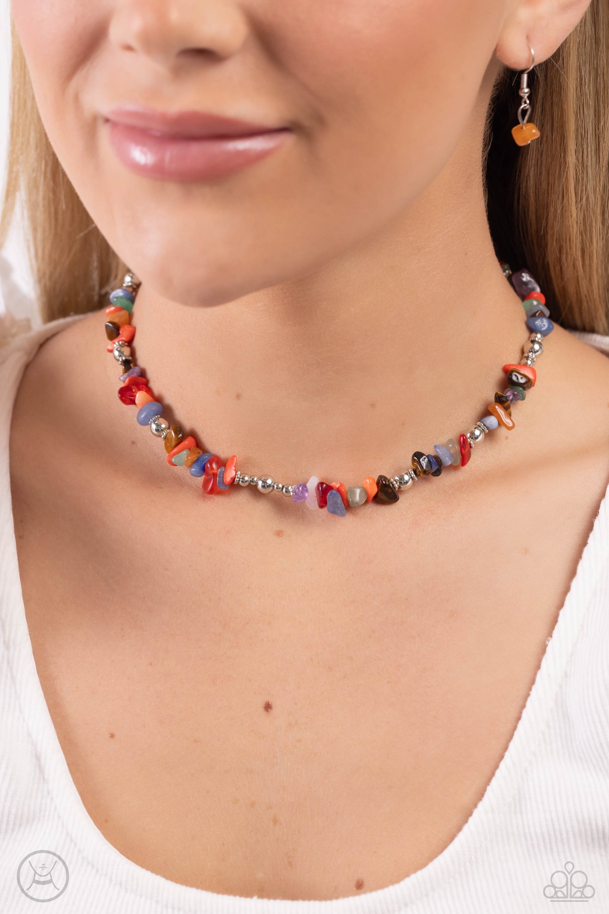 Infused along an invisible string, a chiseled collection of jade, amethyst, lapis, tiger's eye, and other colored stones and various silver beads wrap around the collar for an earthy pop of color. Features an adjustable clasp closure. As the stone elements in this piece are natural, some color variation is normal.  Sold as one individual choker necklace. Includes one pair of matching earrings.   Choker